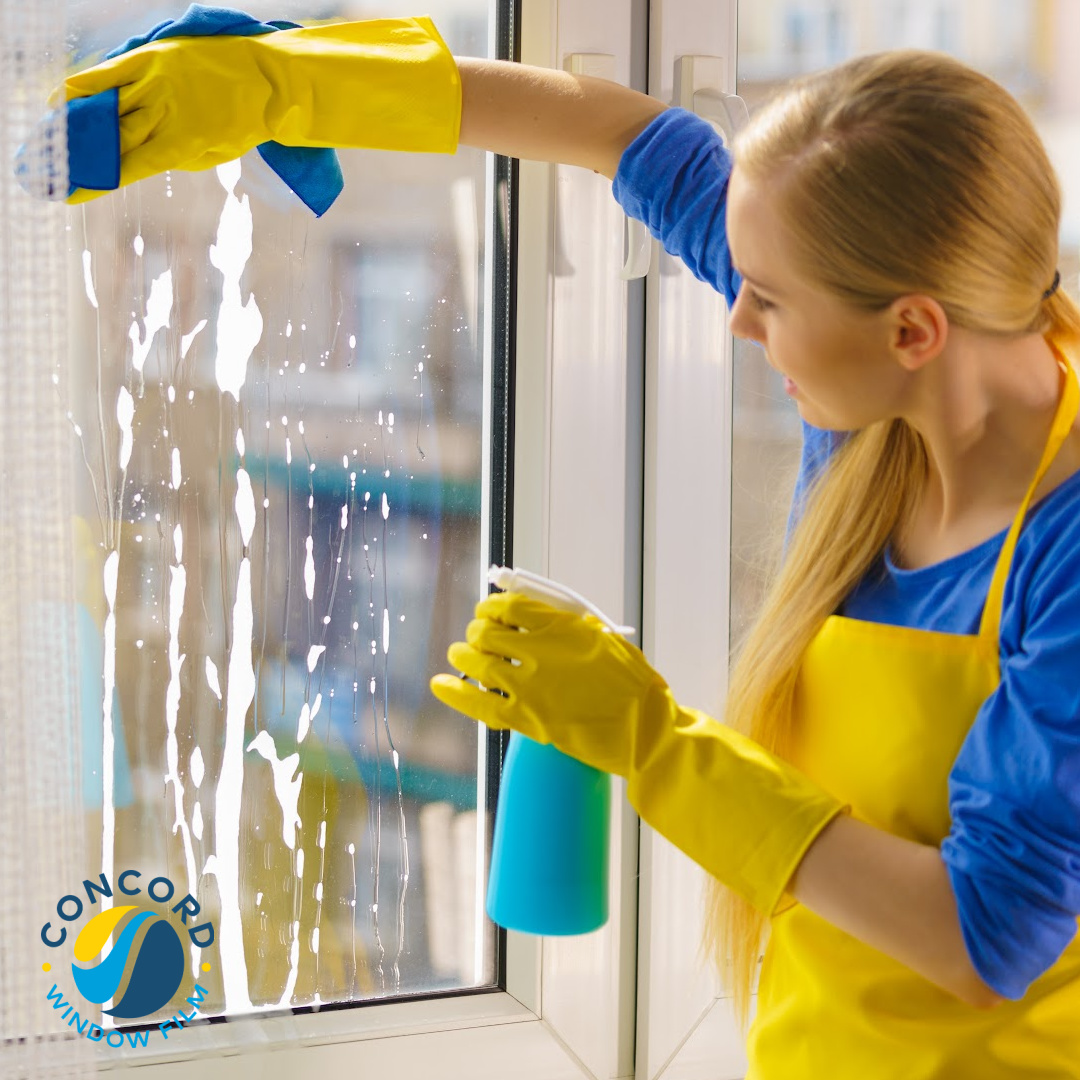 Woman cleaning her windows with window film installed