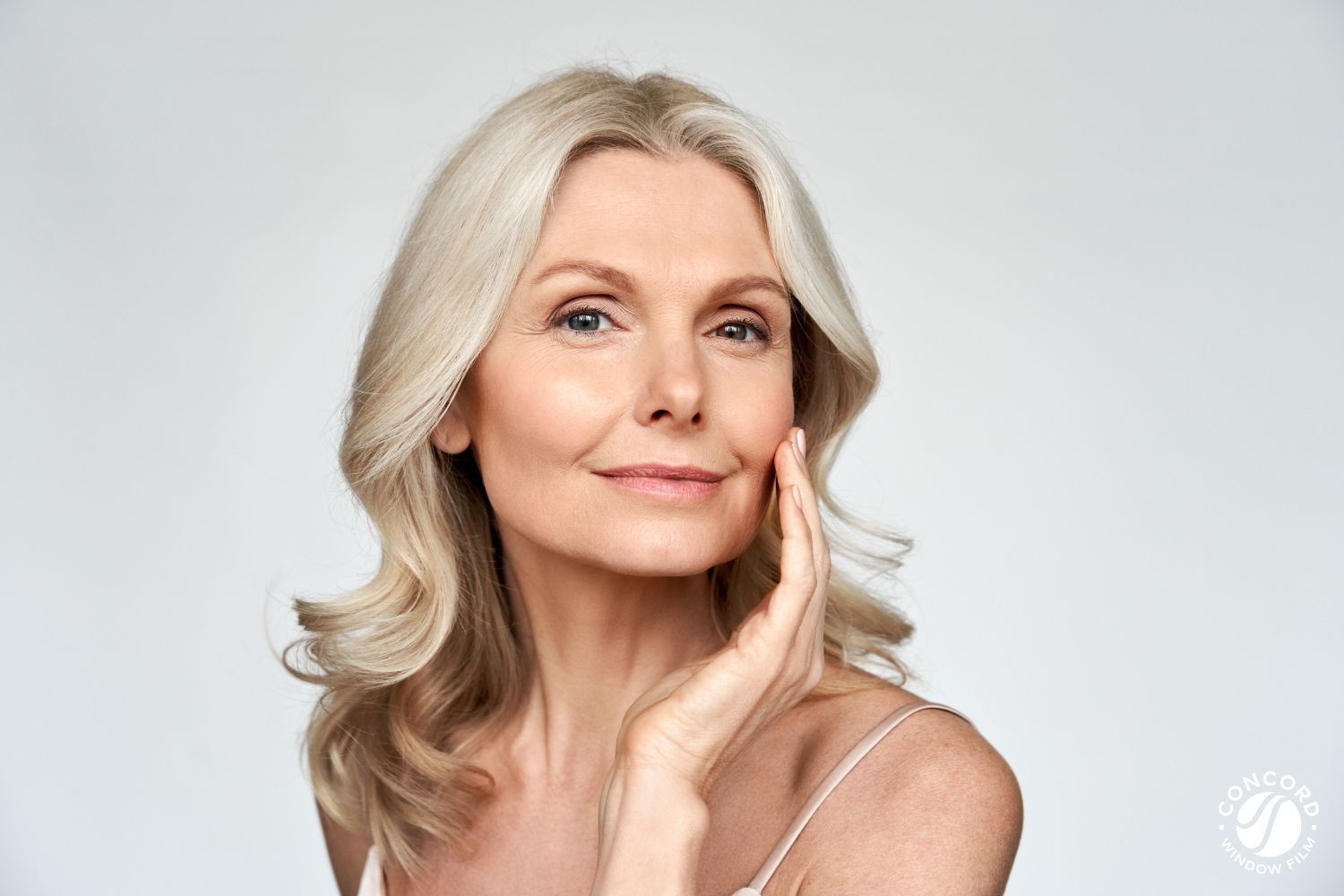 Picture of a beautiful middle-aged woman touching her face for a post on premature skin aging