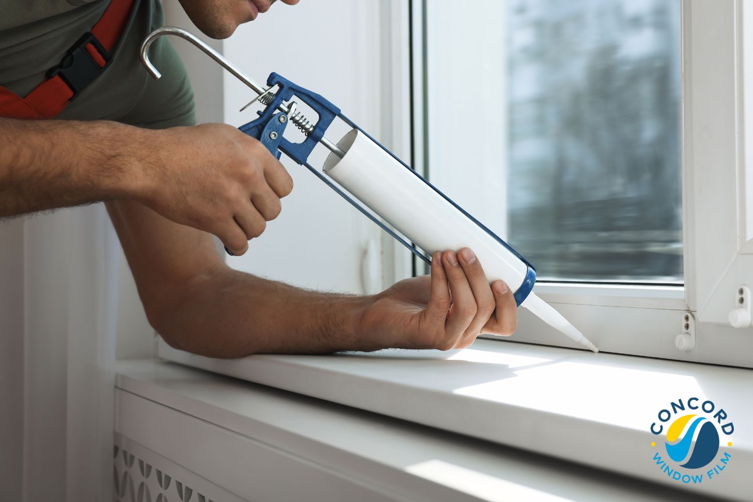 Man caulking a window for a post about winter DIY projects