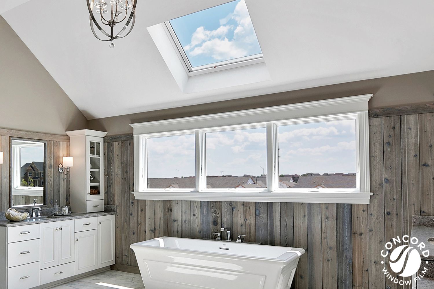 Photo of a sunny bathroom with a skylight over the tub for a post on skylights and window film