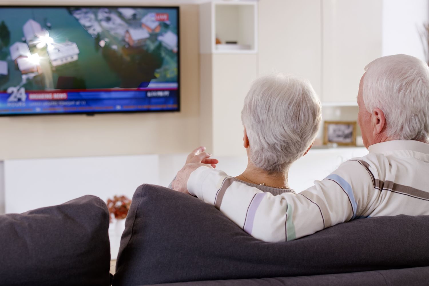 Couple looking at a TV with the glare from the sun on it for a post on how to prevent tv glare